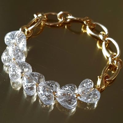 Bracelet chaine à maille large recouvert d'or 24 carats ainsi que de perles cœurs transparentes pailletées en résine. Crée, monté et doré à Paris. Livraison gratuite en France et en Europe. Tout nos bijoux sont sans nickel et or "conflict free". 26 Juin Bijoux